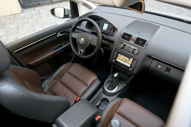 Внутри Touran по-прежнему солидный и удобный, но без изюминки. В богатых комплектациях дефлекторы вентиляции — в хромированных рамках