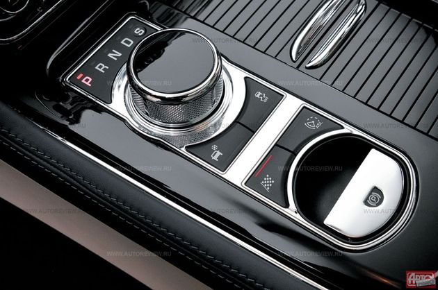 За новой родовой чертой Ягуаров — выезжающей из недр центрального тоннеля рифленой шайбой управления «автоматом» — клавиша электро-механического стояночного тормоза и кнопки управления характером автомобиля. Та, что с клетчатым флагом, активирует «динамичный» режим: подвеска становится собраннее, реакции на газ — острее, а ESP — деликатнее. Та, что со снежинкой, включает «зимний» алгоритм: система стабилизации допускает большую пробуксовку на прямой, но строже пресекает скольжение в поворотах, «автомат» использует повышенные передачи. Короткое нажатие кнопки «ESP off» отключает антипробуксовочную систему, а длительное (более десяти секунд) — всю страхующую электронику, кроме АБС