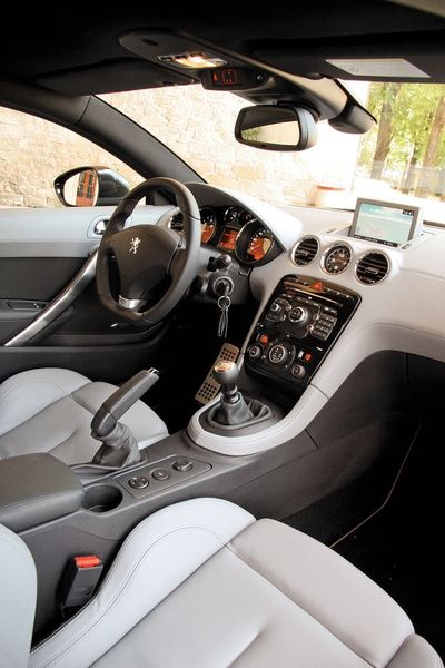 Передняя панель от «триста восьмого» обшита кожей — или искусственной, или натуральной. Руль меньшего диаметра (на фото) входит в спортпакет вместе с «укороченным» механизмом переключения передач и звуковым синтезатором на впуске (у 200-сильной машины спортпакет идет «в базе»)